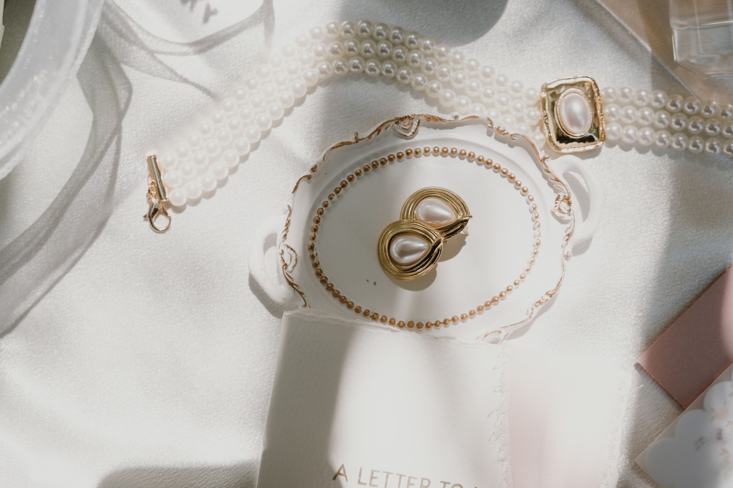 Wedding rings displayed on an elegant white porcelain plate with delicate gold trim.