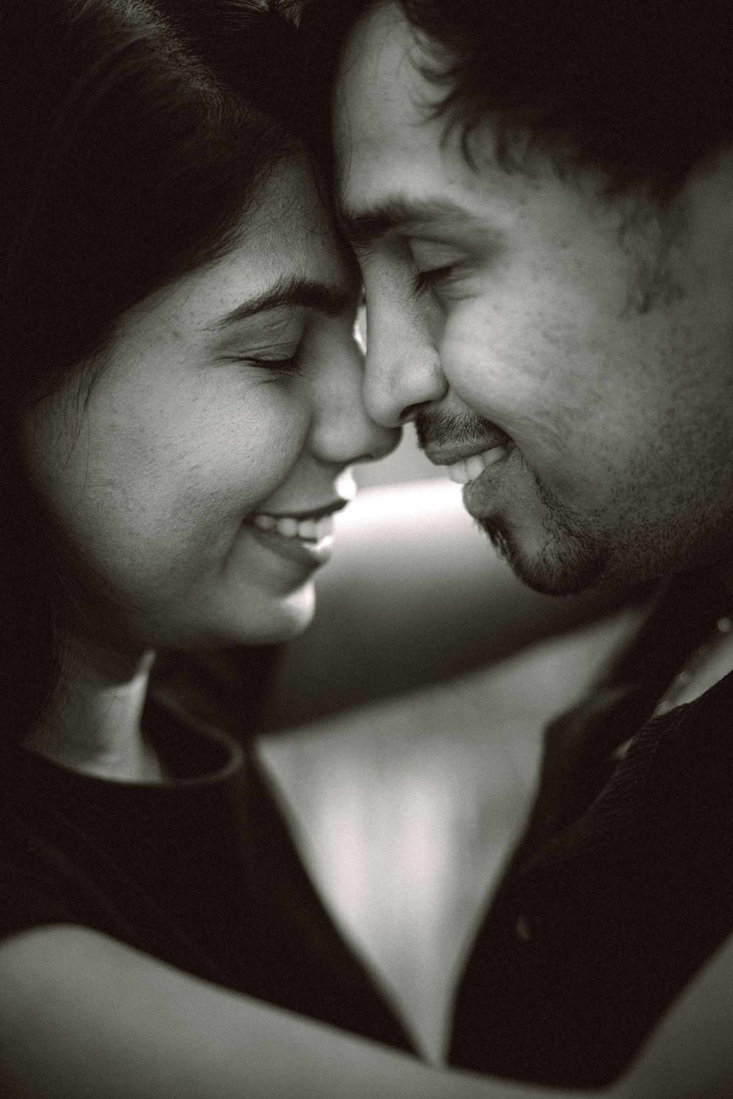 Intimate black and white portrait of couple sharing a tender moment.