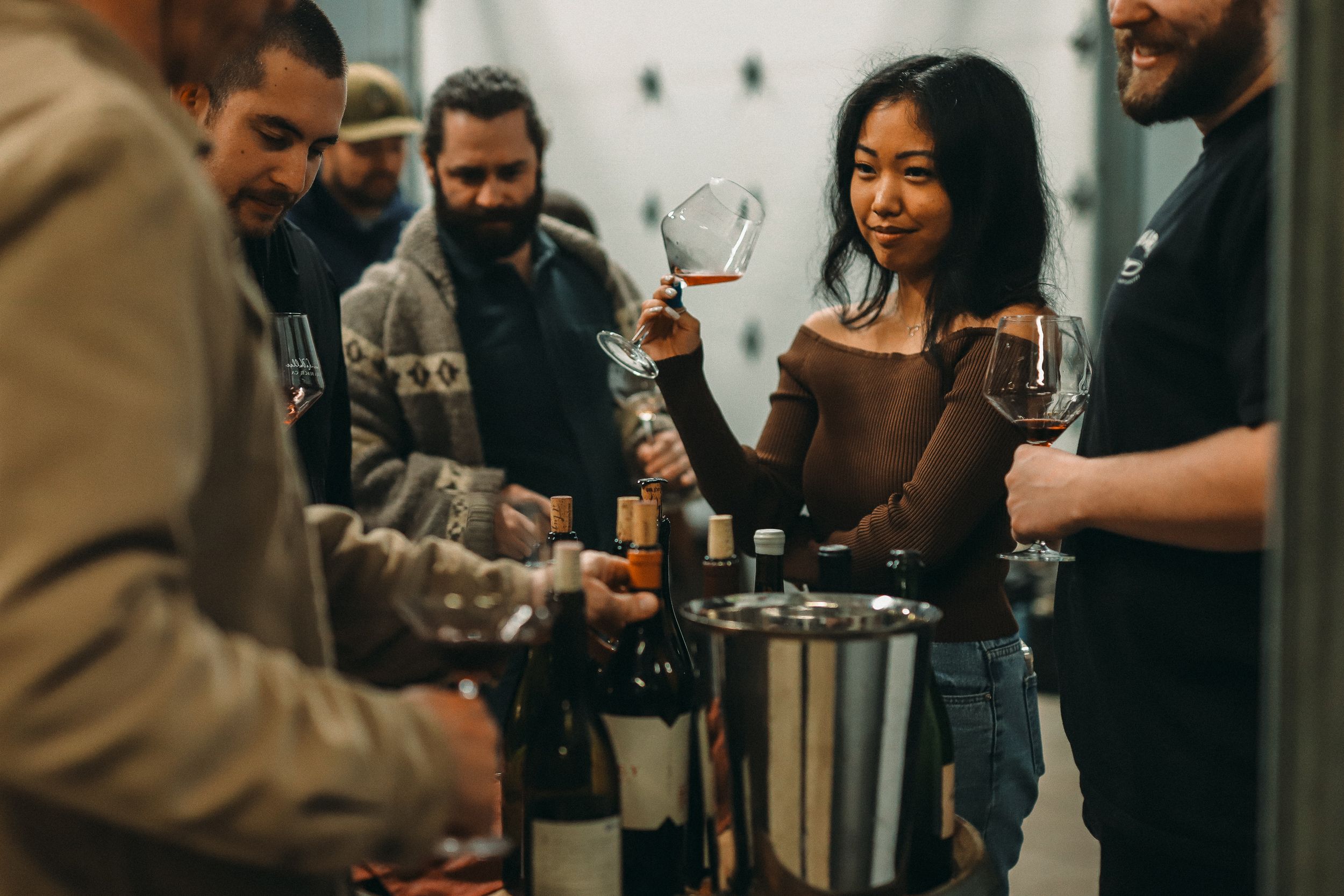 Group of people enjoying wine tasting at a social gathering.
