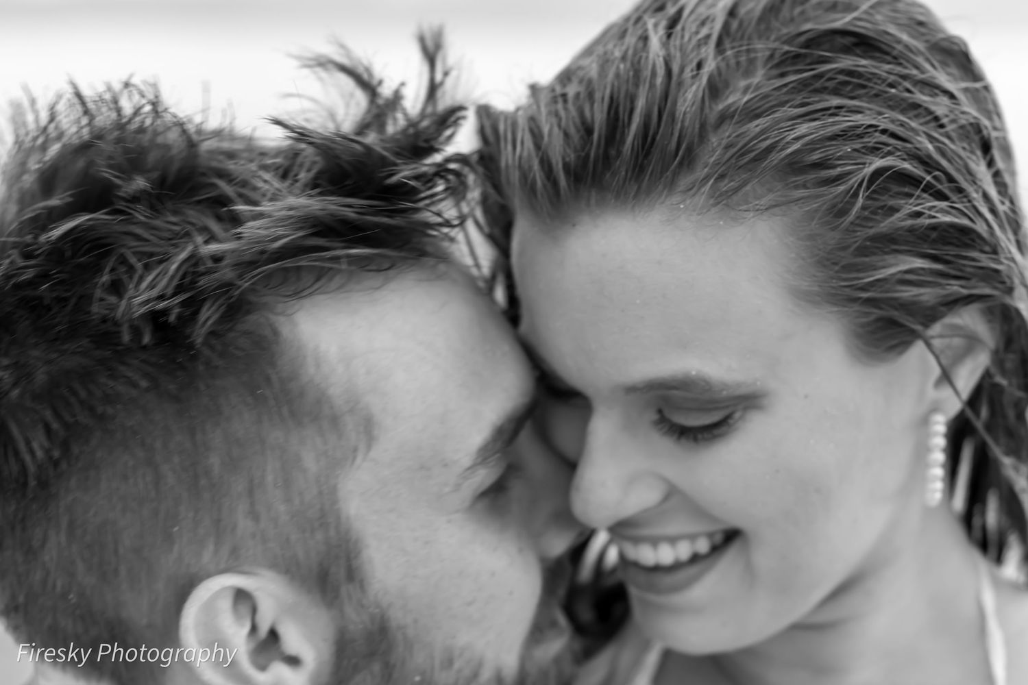 Intimate black and white portrait capturing tender moment between couple.