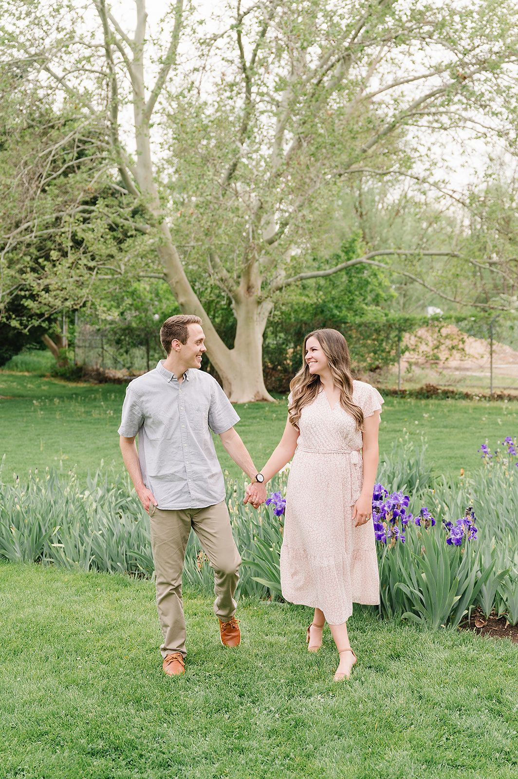 A romantic spring photoshoot among blooming purple irises in a verdant garden setting.
