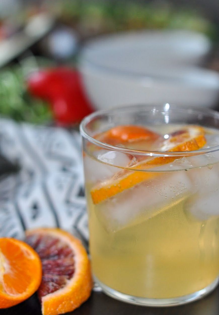 Glass of citrus cocktail with orange slices and ice cubes.