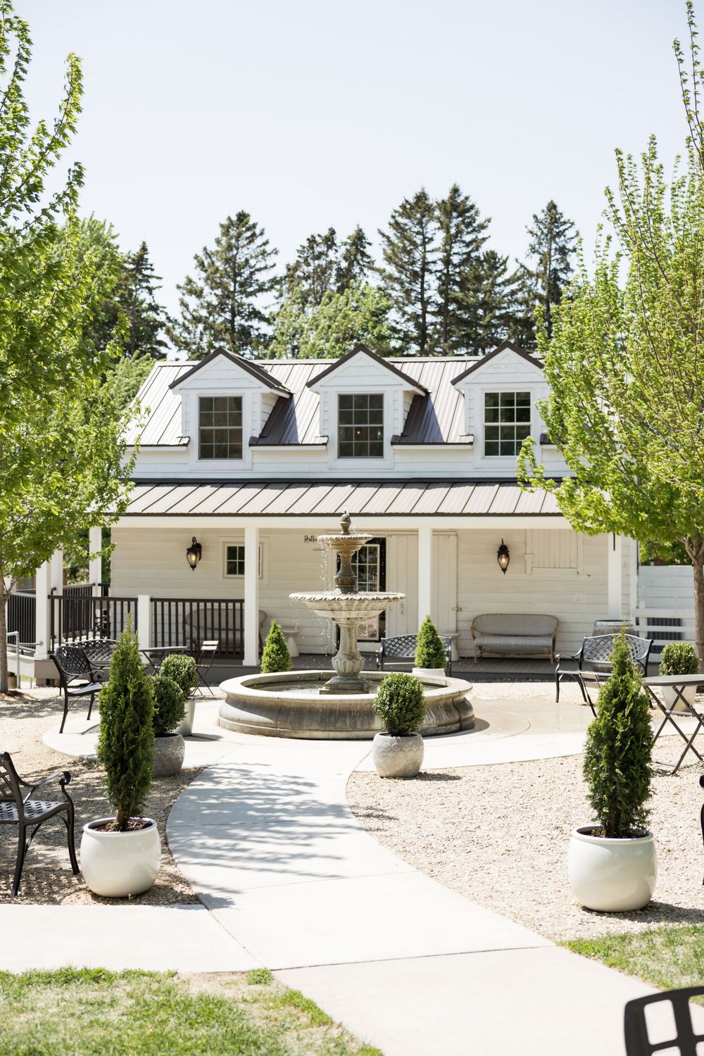 Modern white event venue exterior with landscaped grounds and concrete walkways.