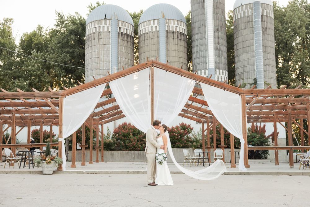 A collage of rustic barn wedding venue photos showing silos, white drapes, and outdoor ceremony setups.