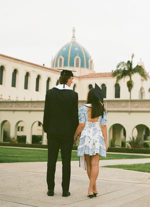 A couple walks and poses together in a Spanish colonial architecture setting at the University of San Diego.