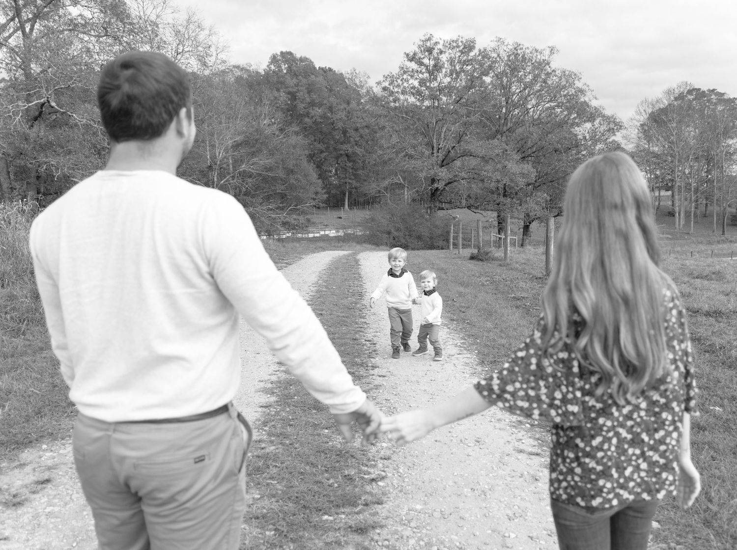 Black and white photo of people walking together on a countryside path.