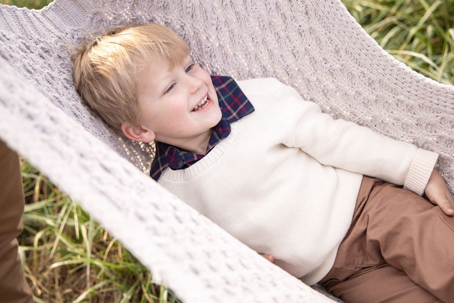 A candid moment of laughter while resting on a white blanket outdoors.