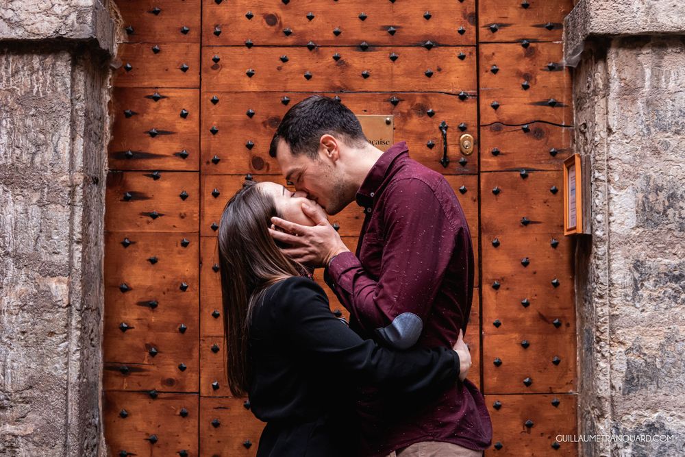 Romantic sequence against an ornate wooden door with metal studs.