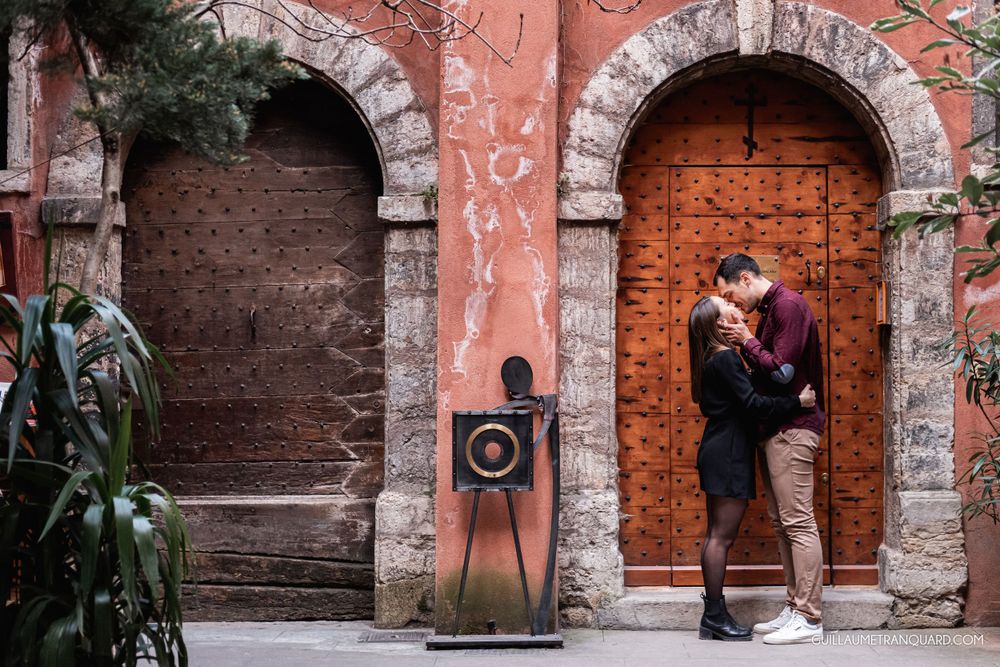 Stone archways frame rustic wooden doors with decorative street art between them.