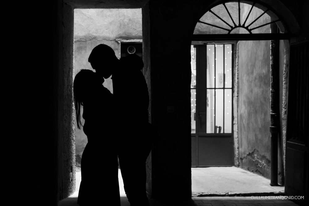 Silhouetted figures in an architectural archway with dramatic lighting.