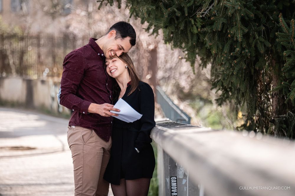 Sunlit outdoor scene with couple sharing an intimate moment against stone architecture.