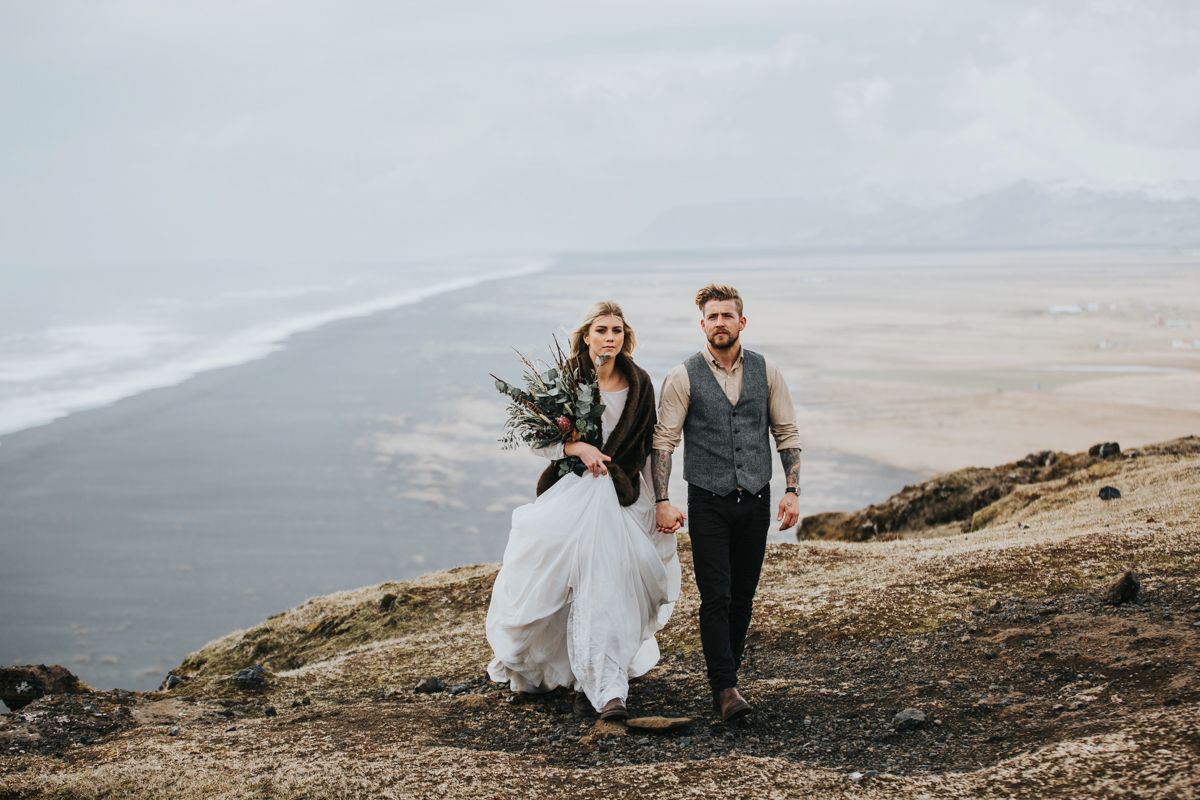 Adventurous wedding photo session on rugged cliffs overlooking a dramatic coastline.