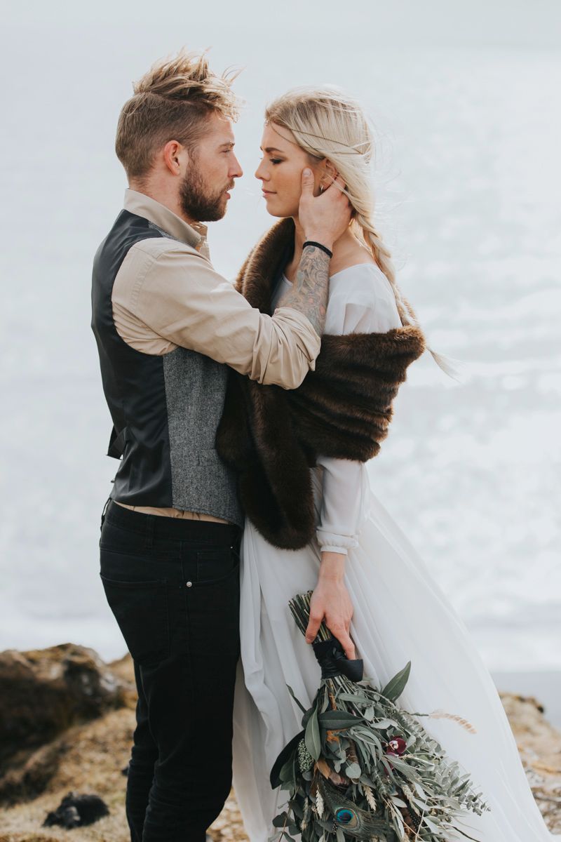 Artistic wedding portrait showing intimate embrace on cliffside.