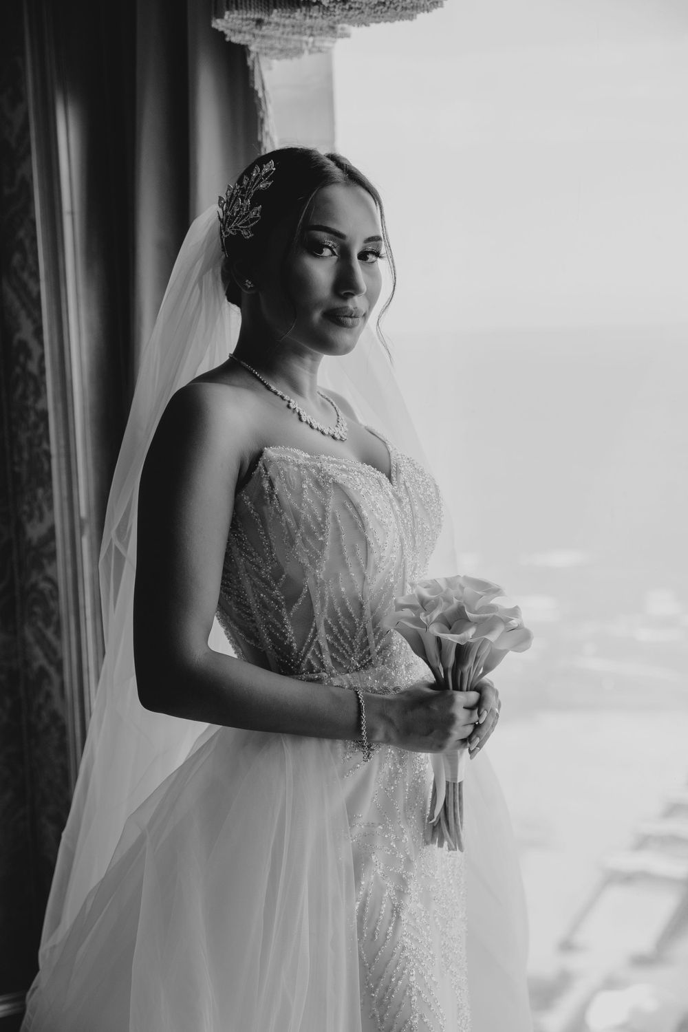 Black and white bridal portrait showing intricate lace detail and jewelry.