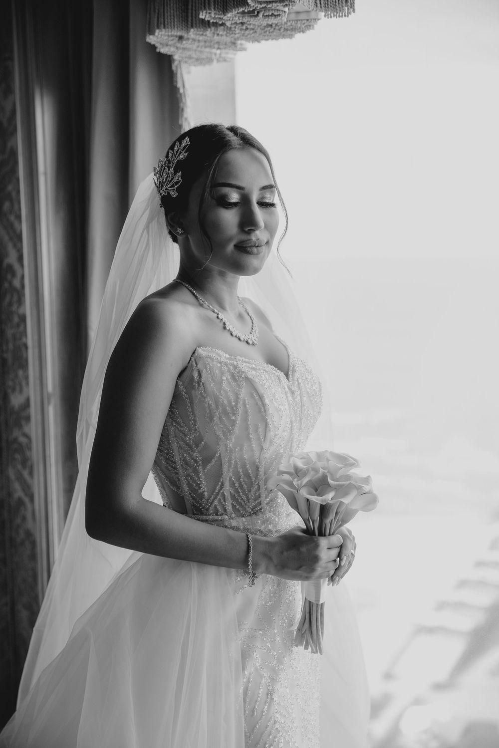 Intimate black and white portrait of bride with closed eyes holding bouquet.
