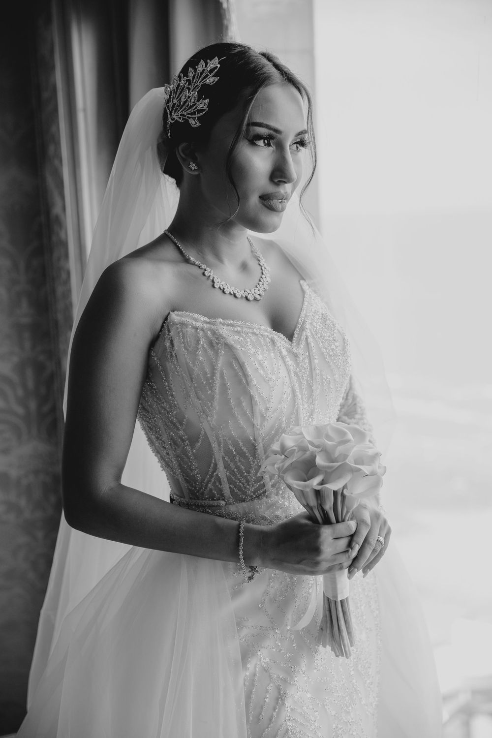 Elegant bridal portrait showcasing detailed veil and statement necklace.