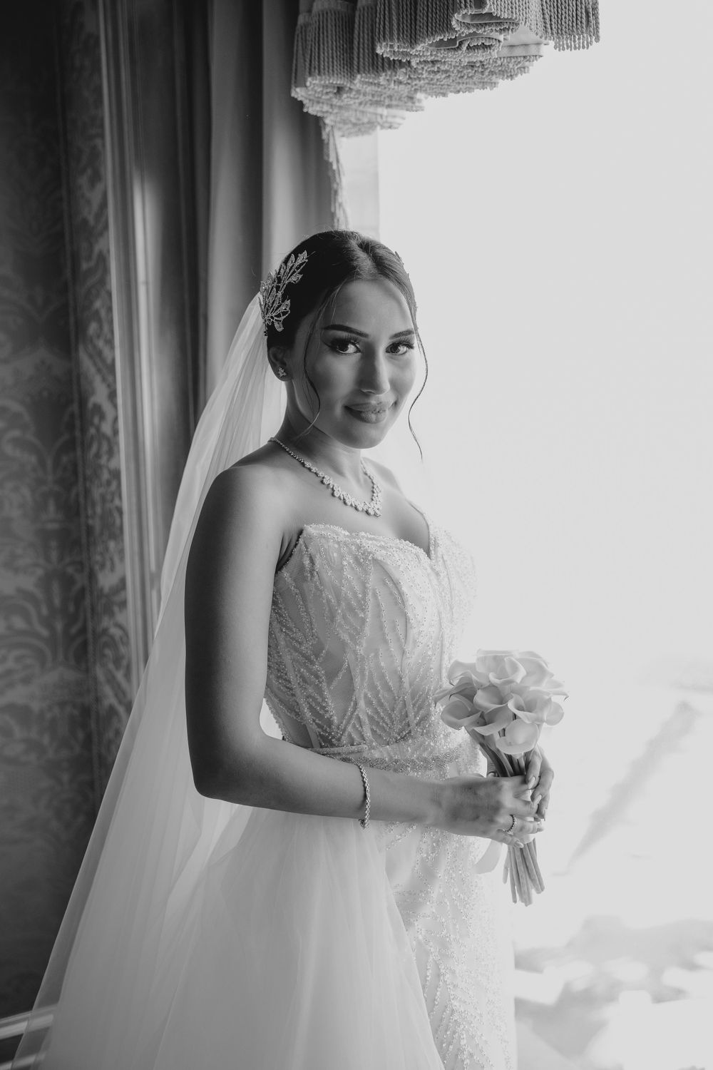 High-contrast bridal portrait showing detailed bodice and crystal hair accessories.