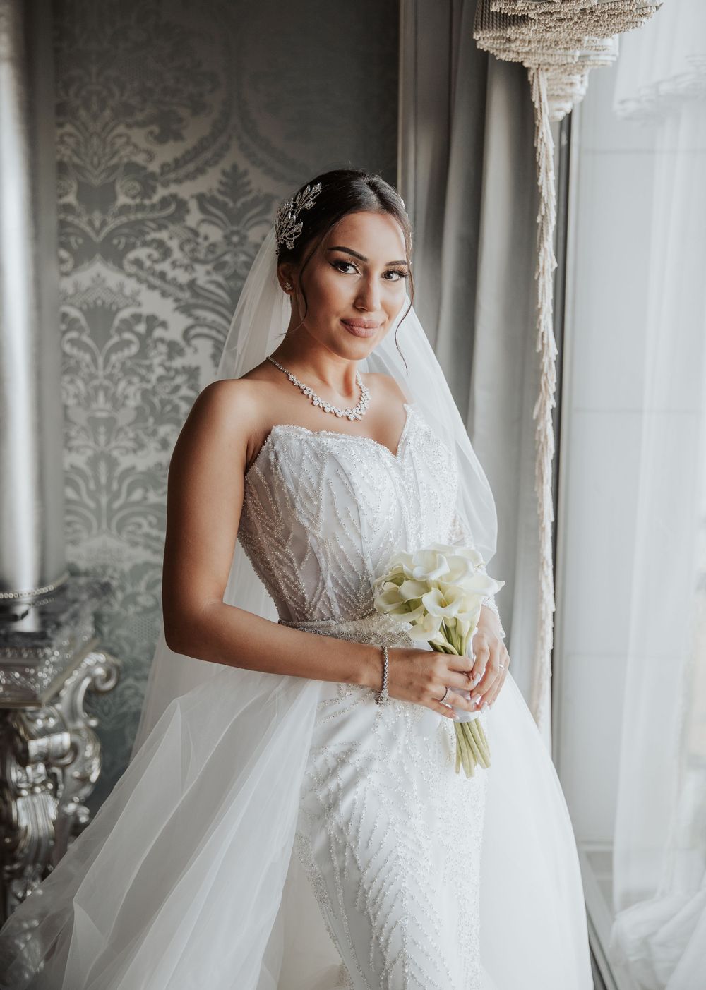 Elegant bridal portrait showcasing a strapless lace wedding dress and delicate necklace.