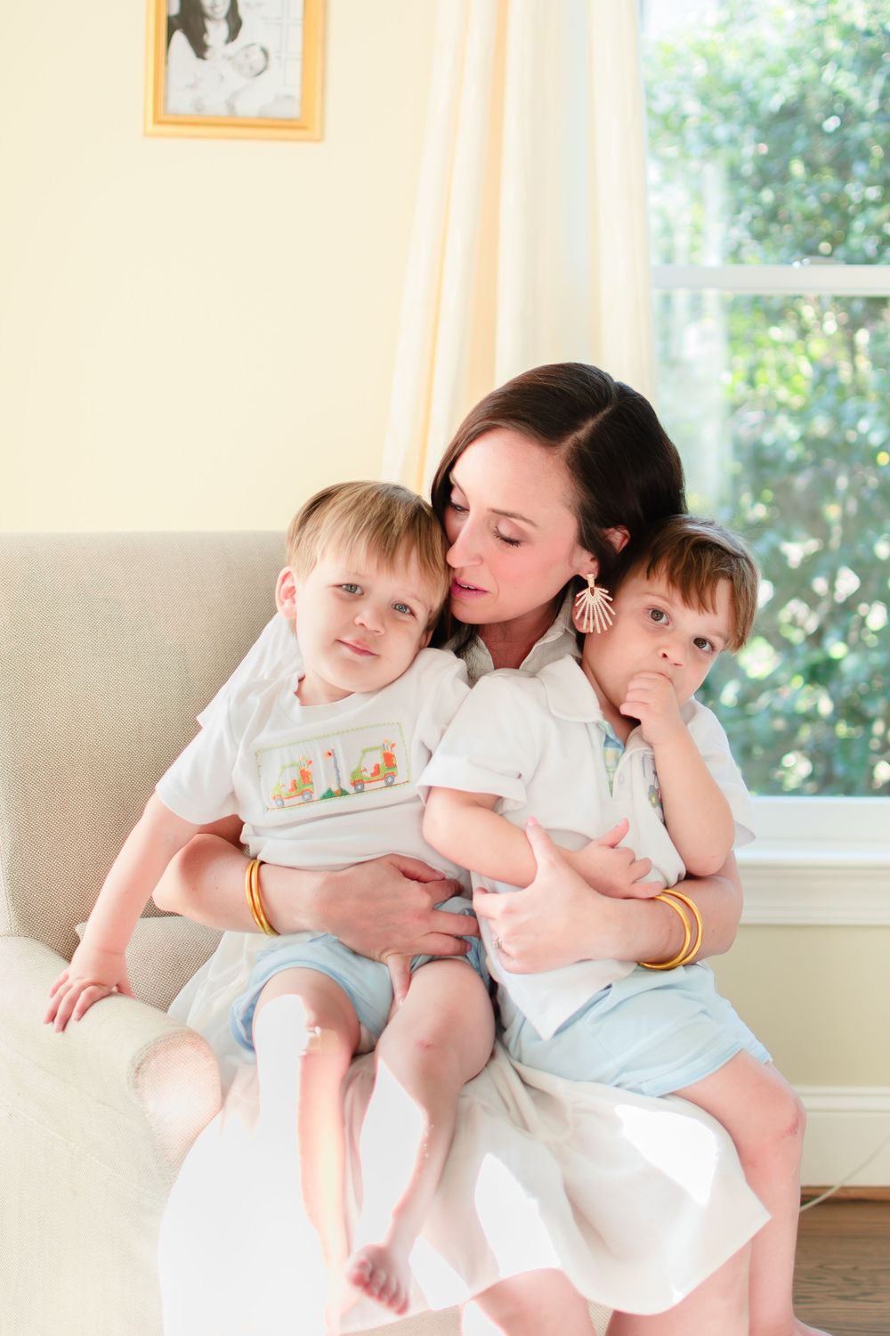 A mom snuggles her twin toddlers on he lap in their Winston-Salem home.