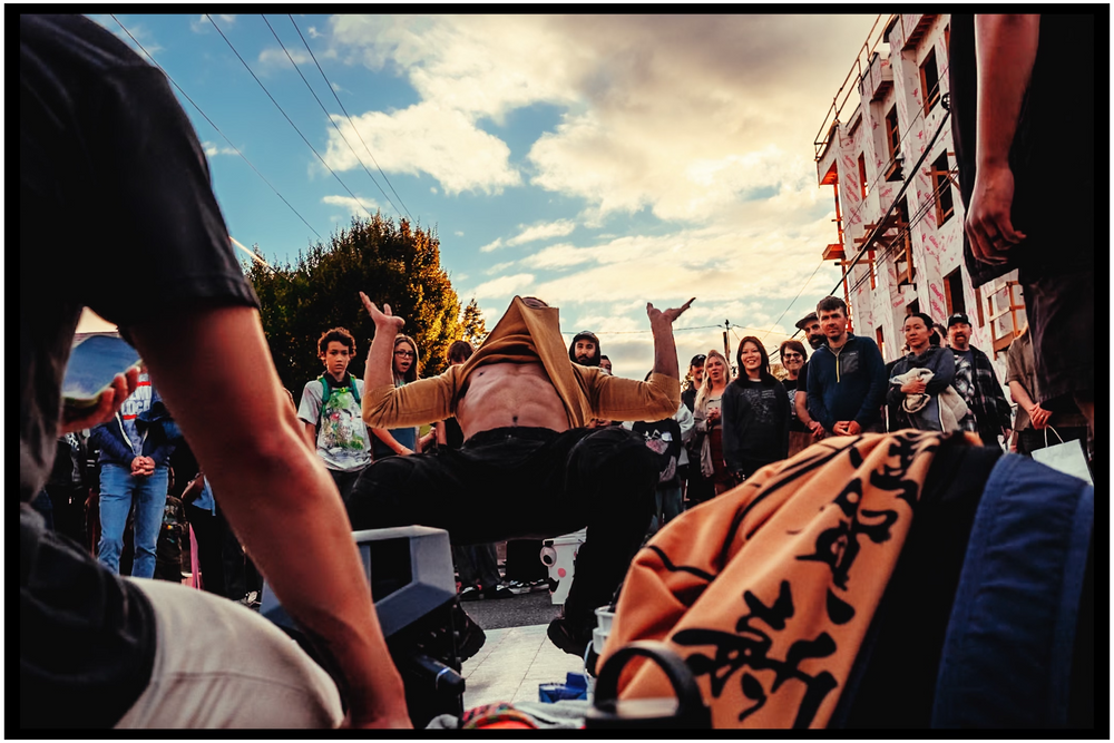 Crowd gathering around performers at outdoor street festival. Portland street photography