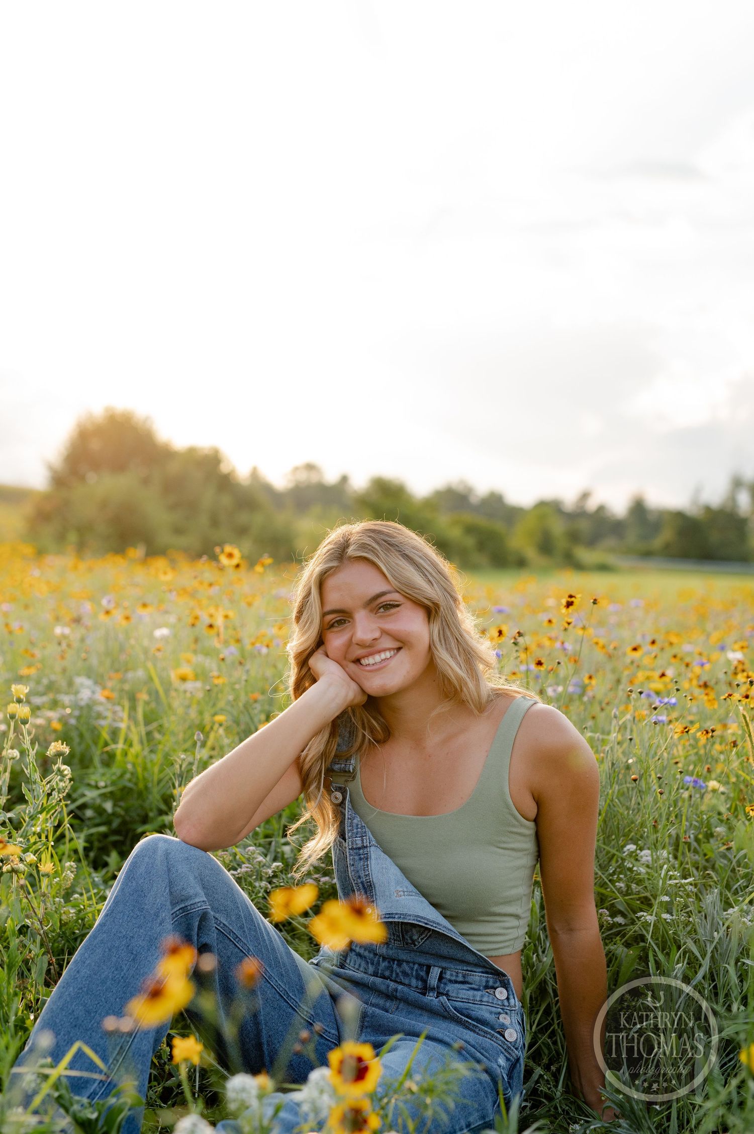 A relaxed outdoor portrait in a field of yellow flowers during golden hour.
