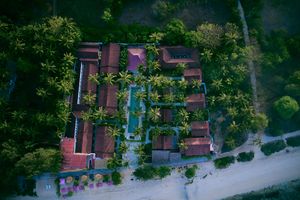 Aerial view of resort buildings with swimming pools and lush tropical landscaping.