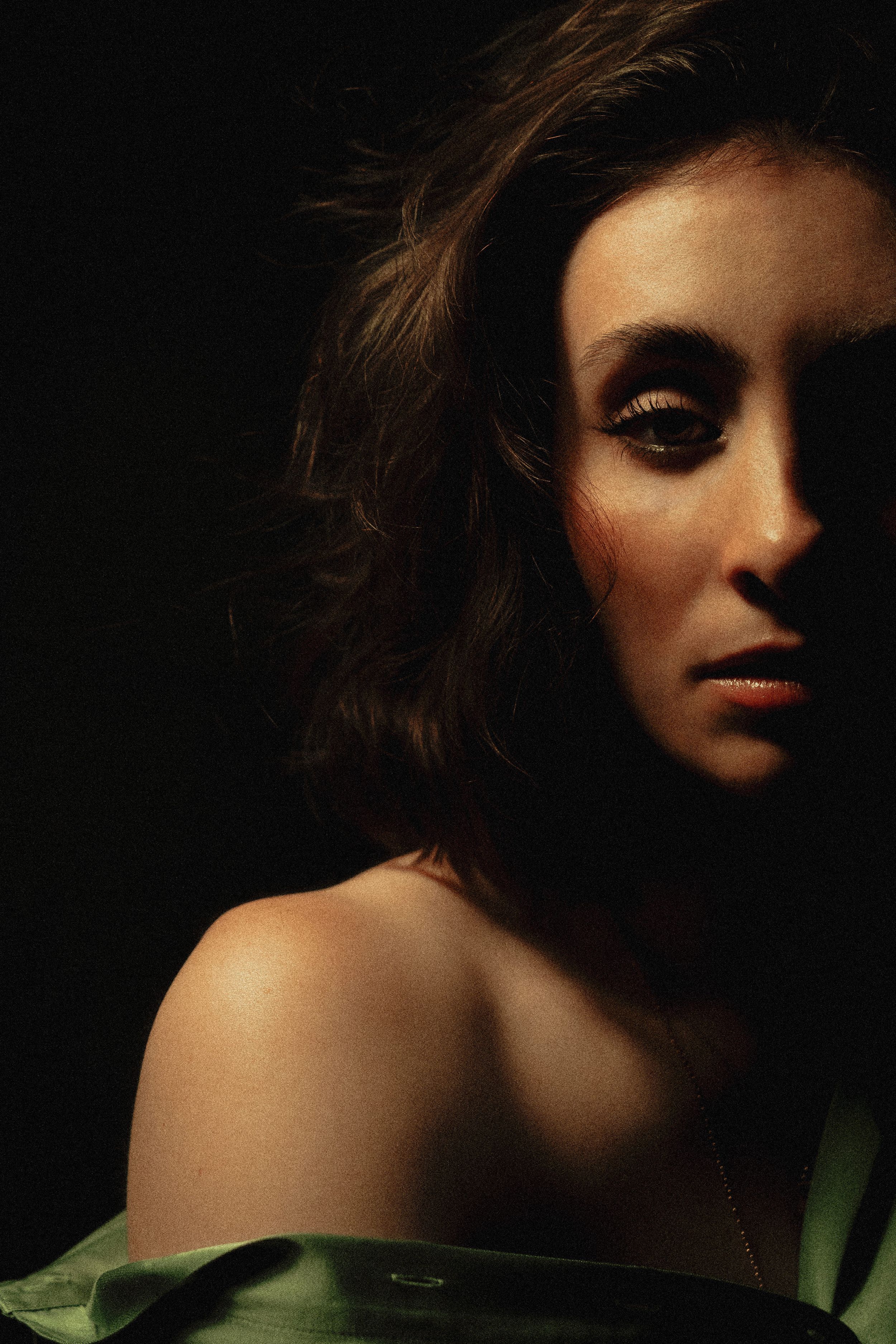 Moody portraits with dramatic shadows and green accent lighting creating mysterious atmosphere.