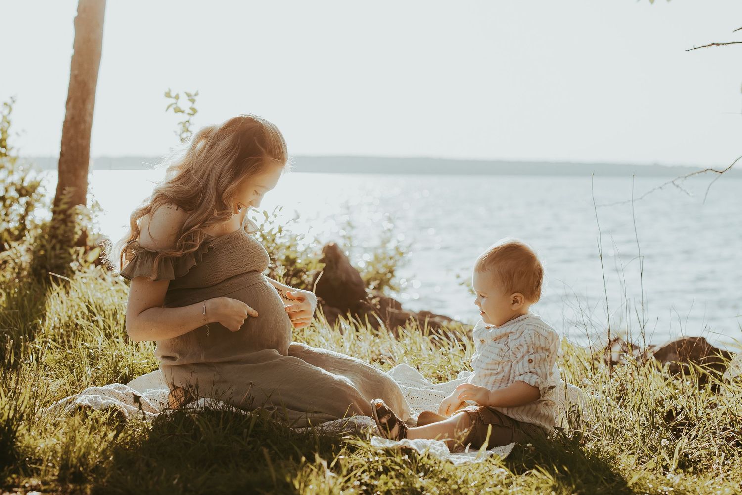 A couple shares an intimate moment at sunset by the water.