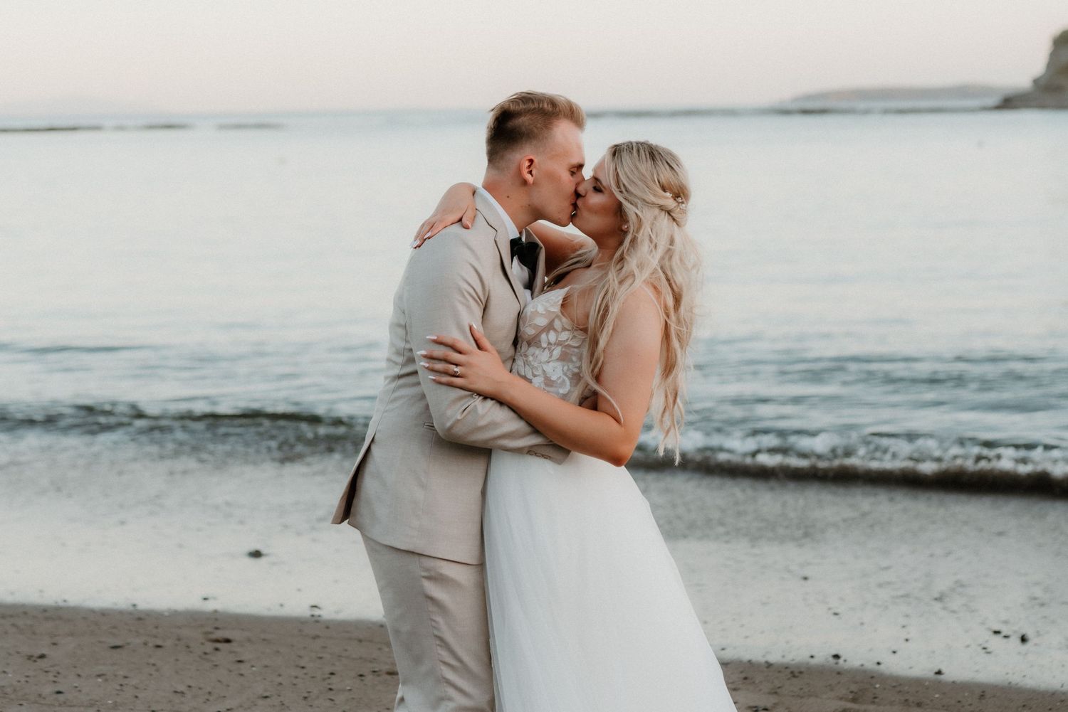 A romantic sunset beach moment with gentle waves and coastal scenery in the background.