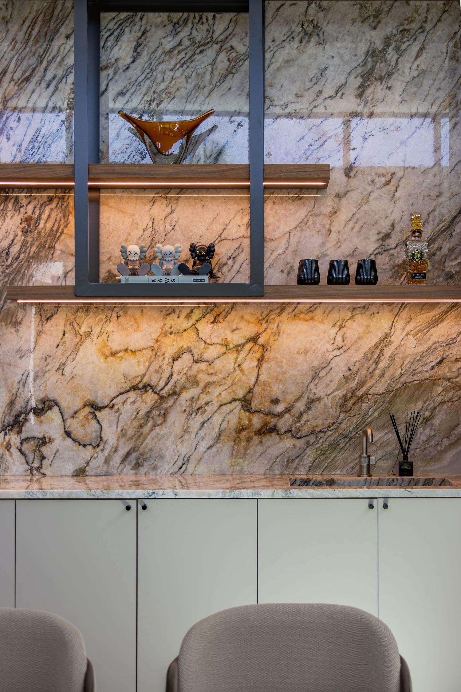 Luxurious interior detail showing marble wall paneling with built-in shelving and cabinet storage.
