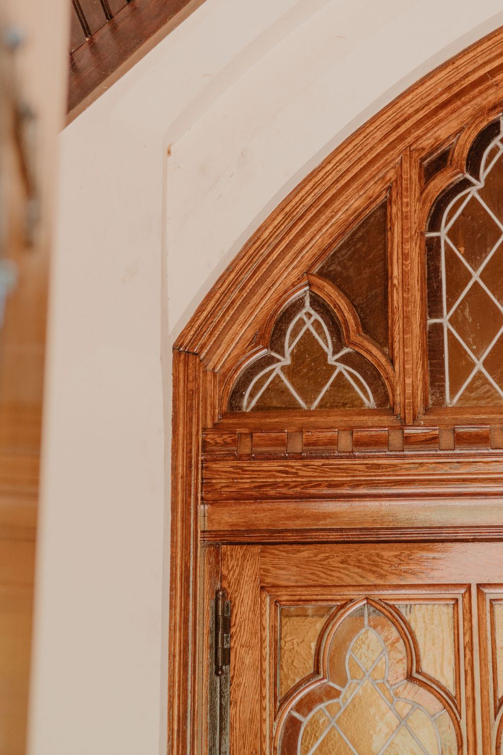 Detailed wooden door frame with Gothic arch and decorative tracery in a church.