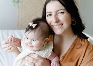 Light-filled lifestyle image, mother holding daughter close, soft and heartfelt.