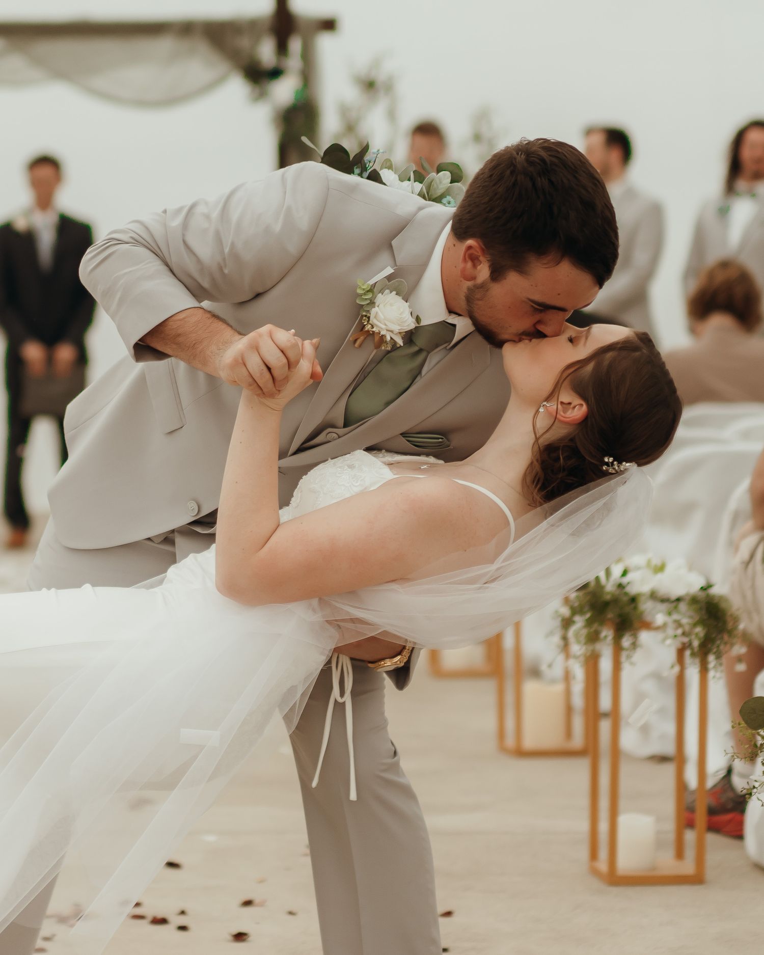 Groom dips and kisses his bride on the way down the aisle to exit their ceremony