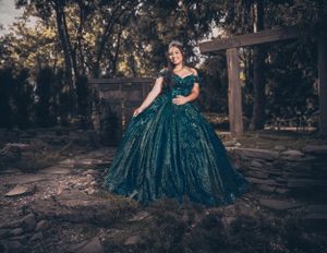 An elegant teal quinceañera dress captured in a rustic outdoor setting.