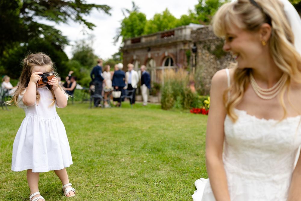 A collage of outdoor wedding moments showing a bride in a white dress walking through a garden setting.