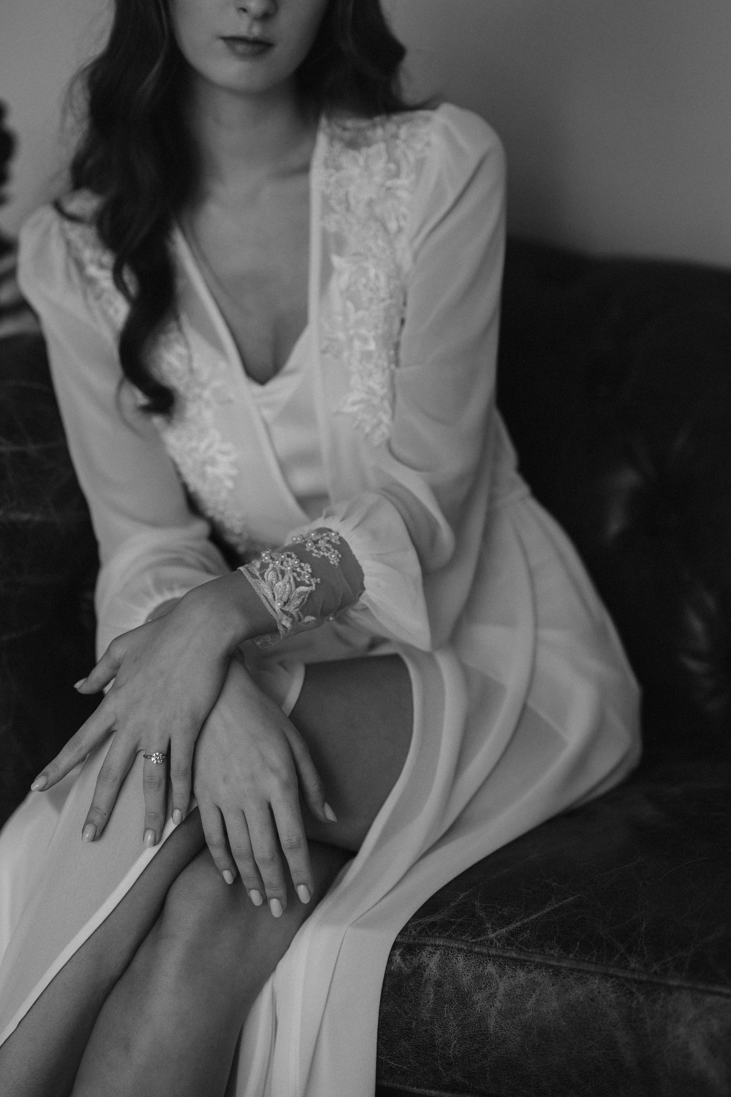 Elegant black and white boudoir photo showcasing lace bridal robe details.