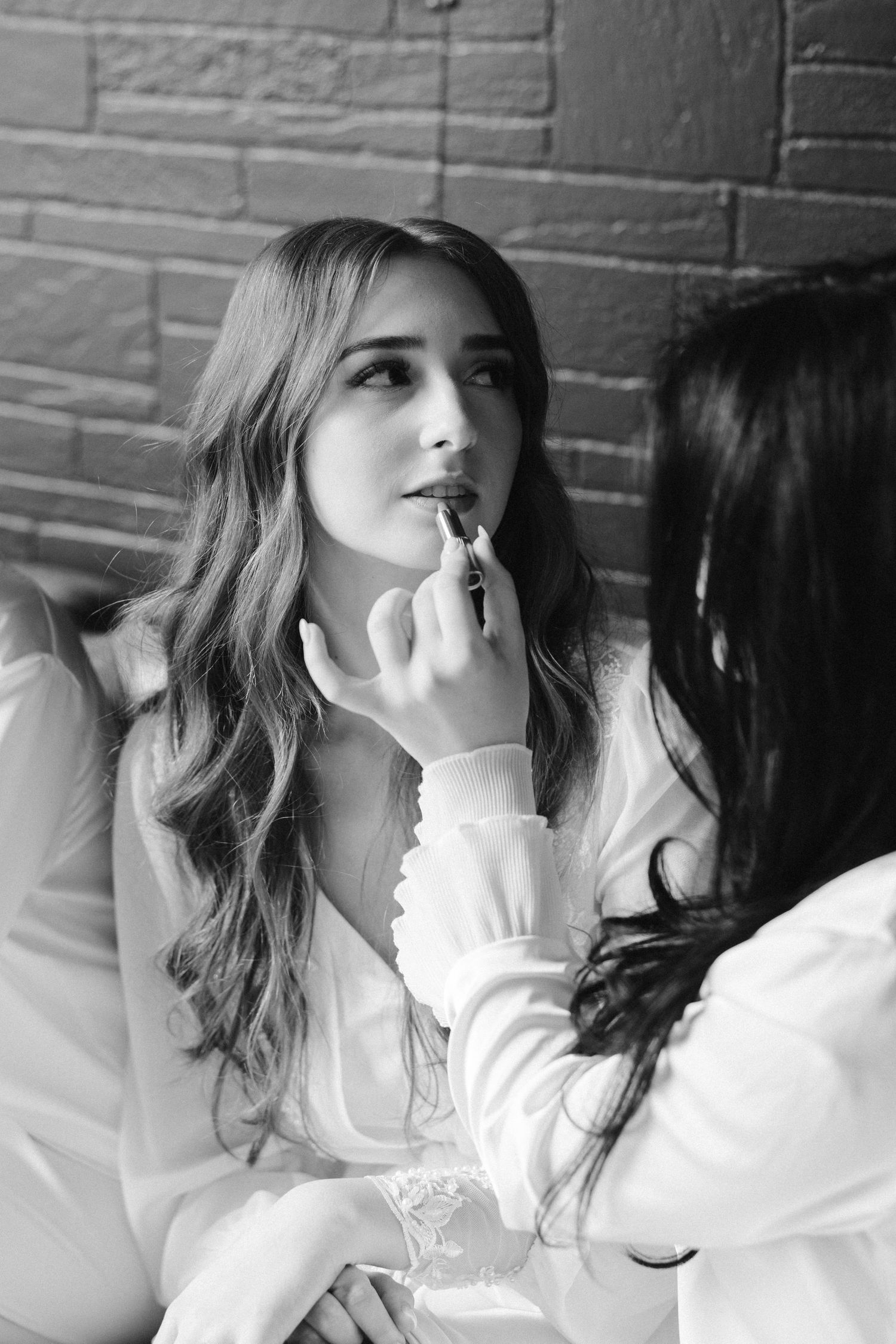 Black and white photo of wedding day makeup application.