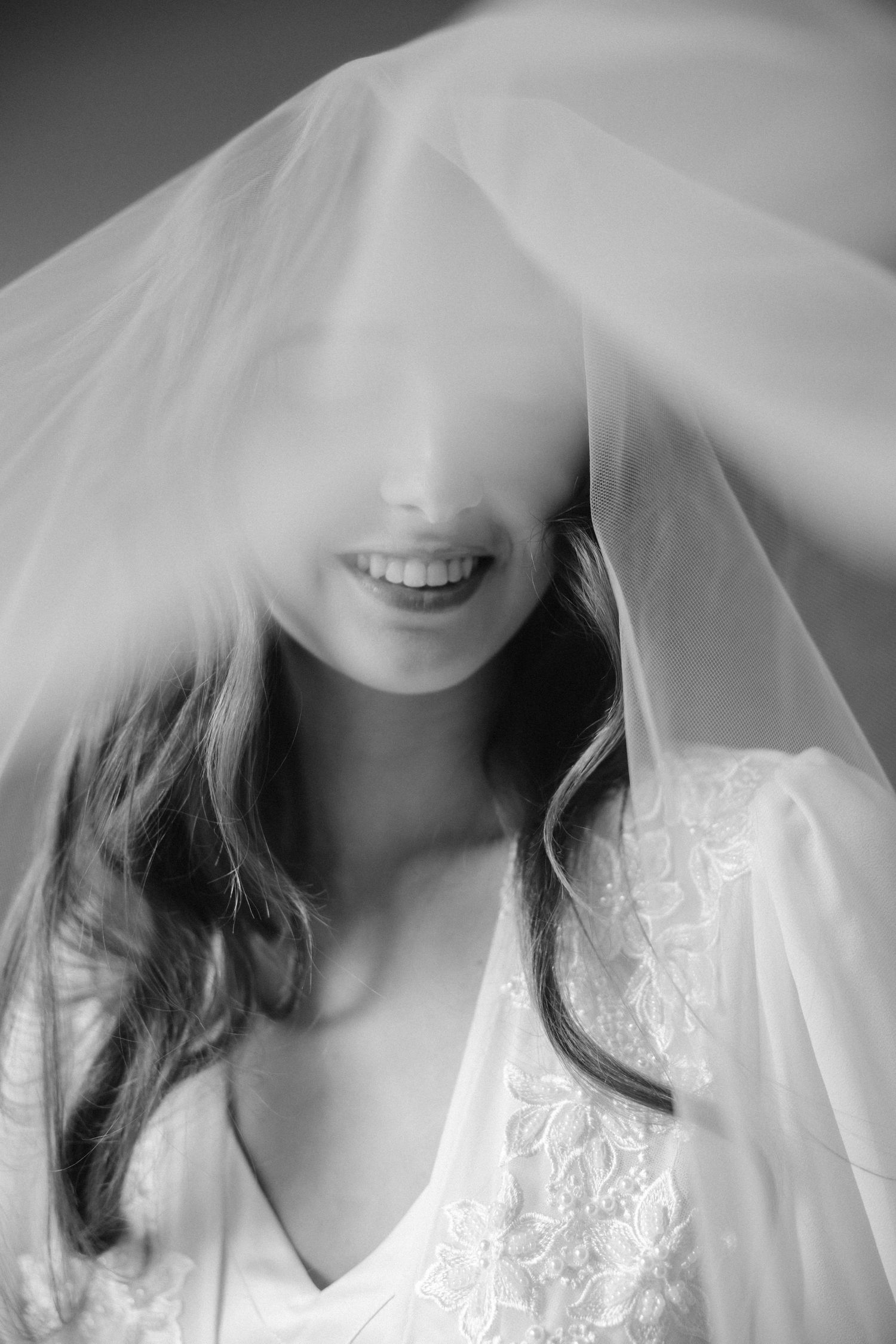 Artistic black and white portrait showing delicate bridal veil details.