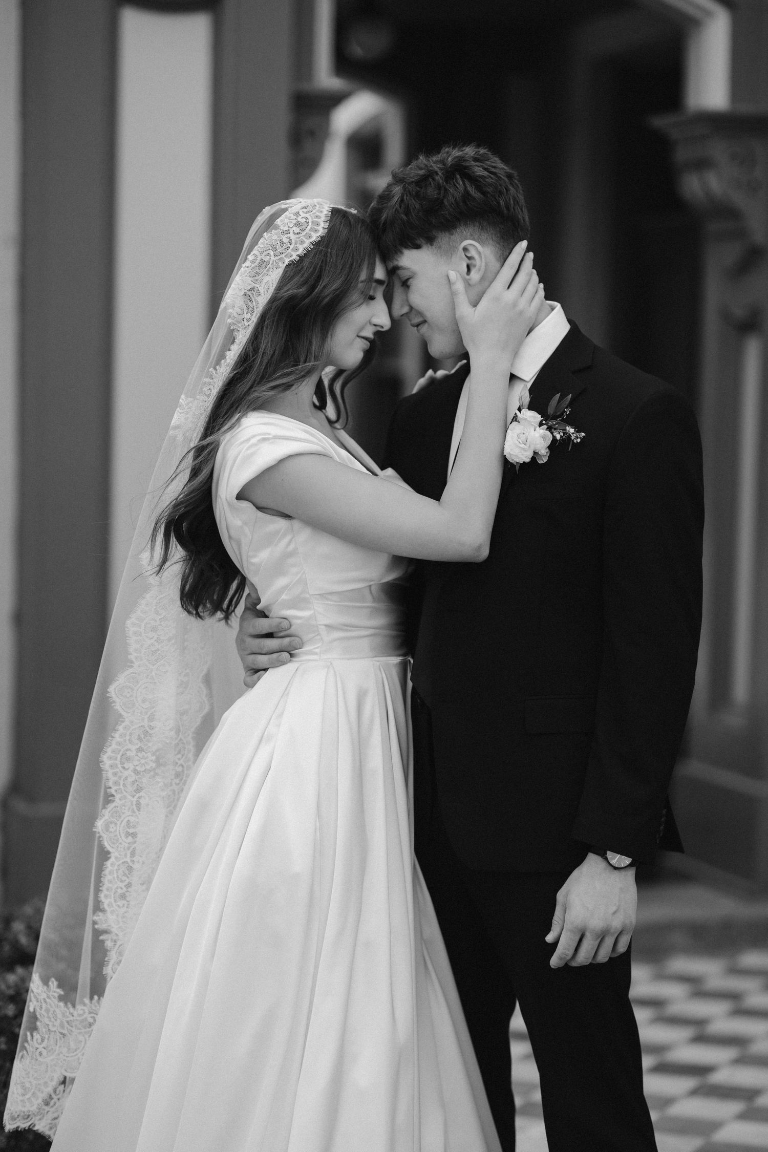 Intimate black and white portrait of newlyweds sharing a tender moment.