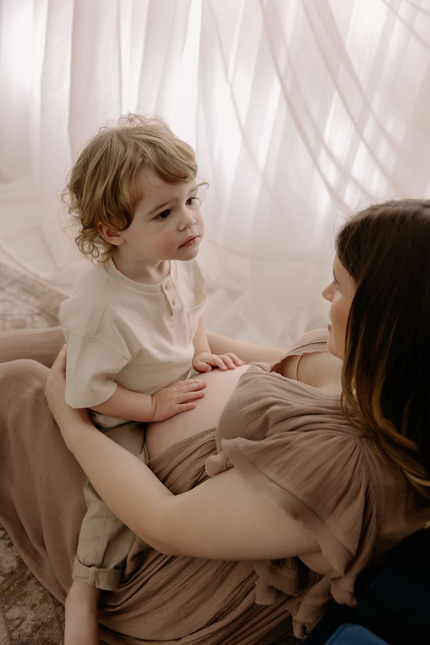 little boy touching Mum pregnant belly during photoshoot with LM Family Photography