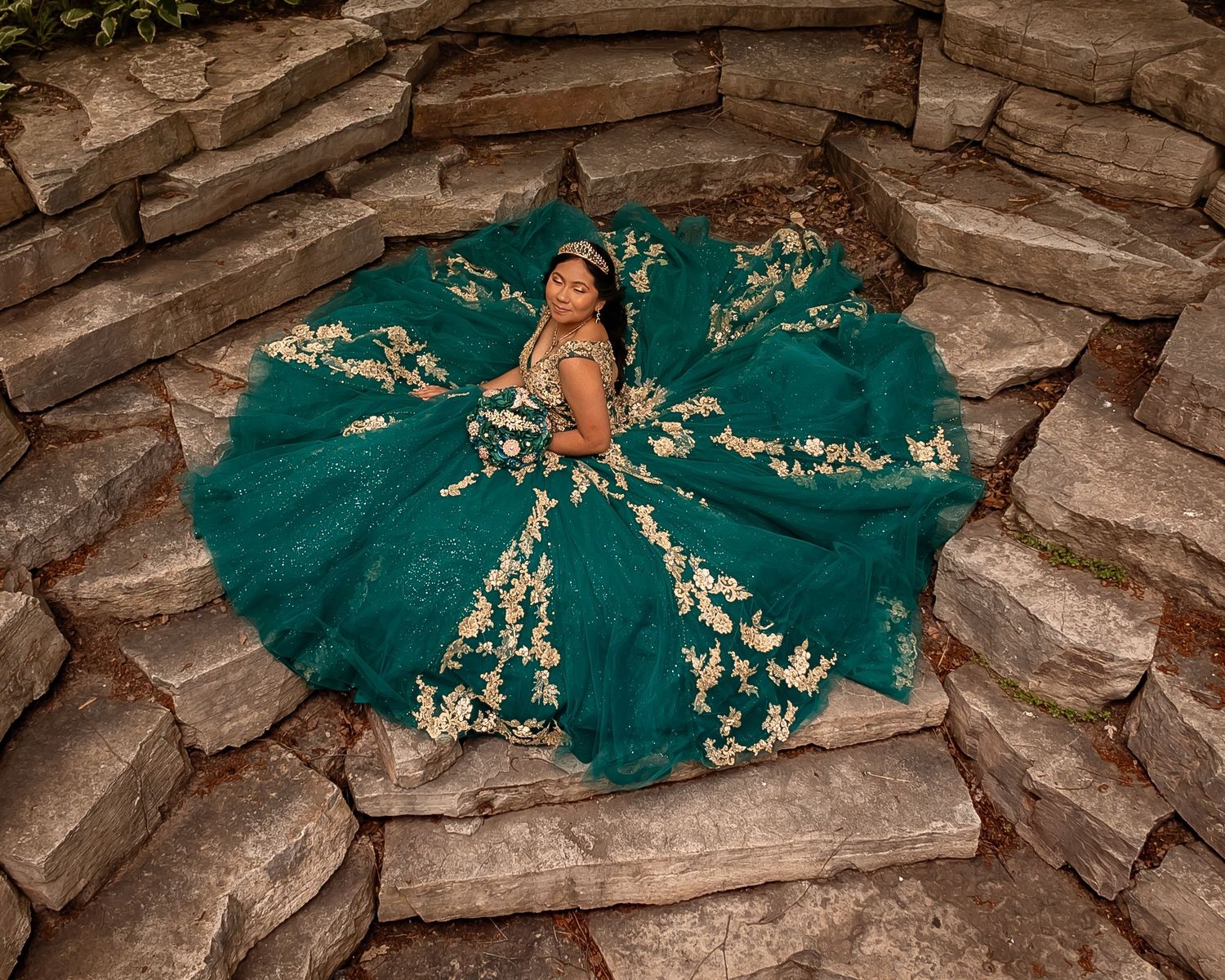 Emerald green dress with gold details spreads in perfect circle on stone steps.