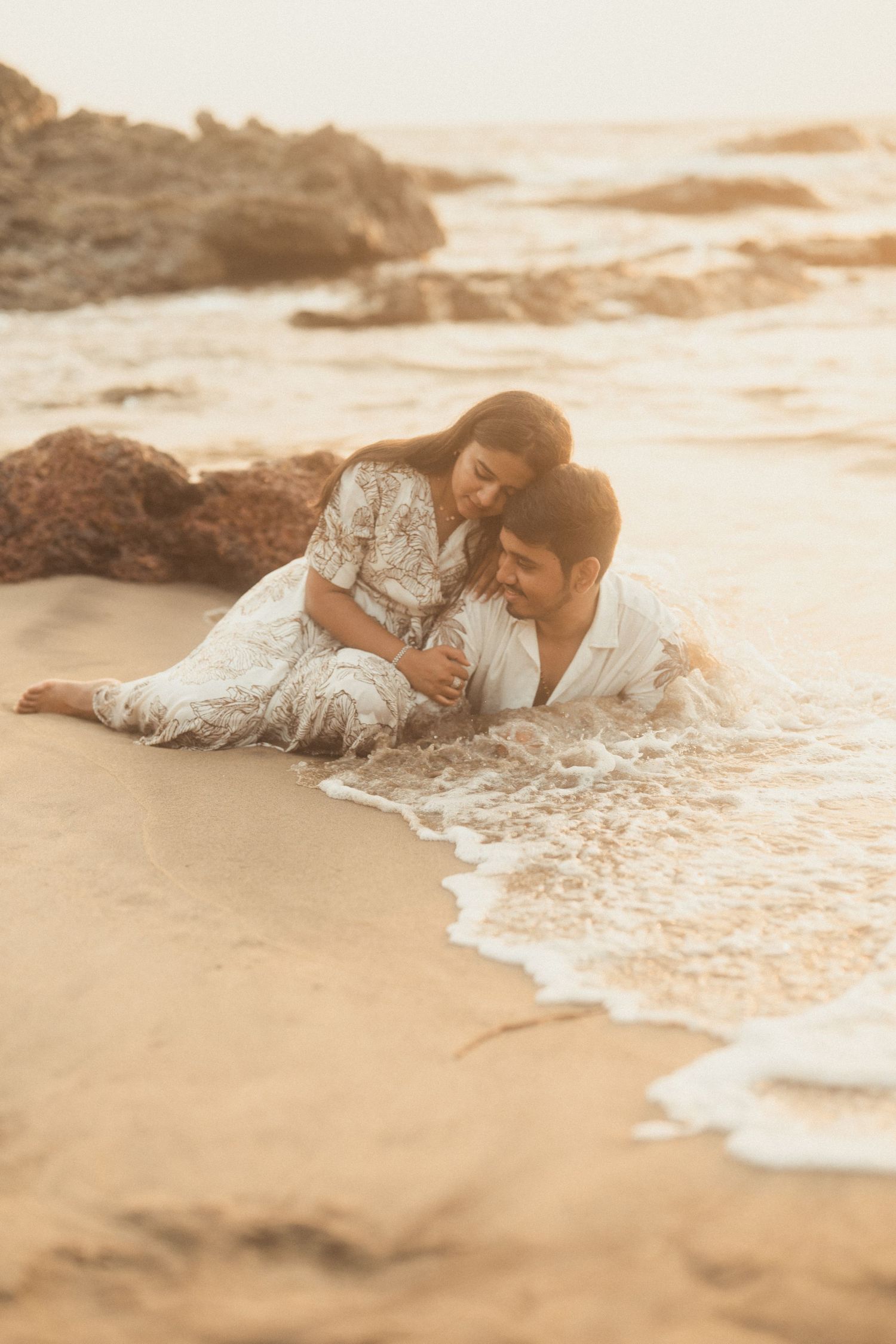 Romantic beach scene with waves lapping at shore during golden hour.