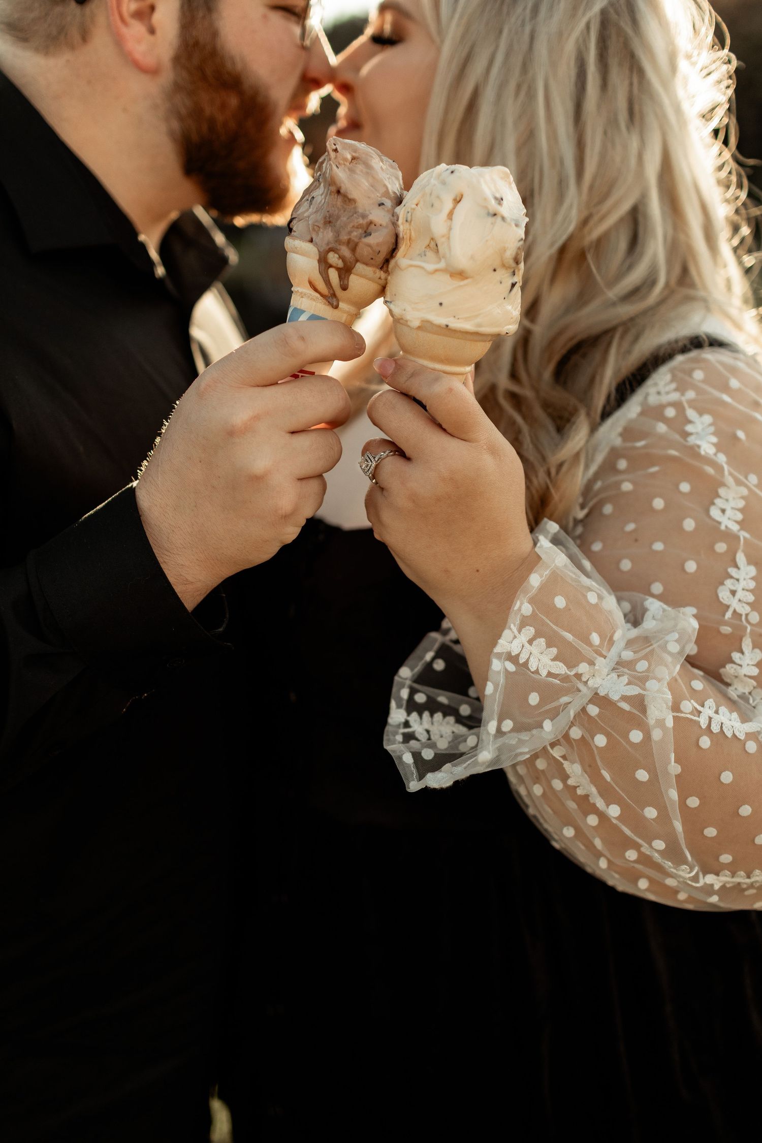 A romantic moment shared over ice cream cones in warm lighting.