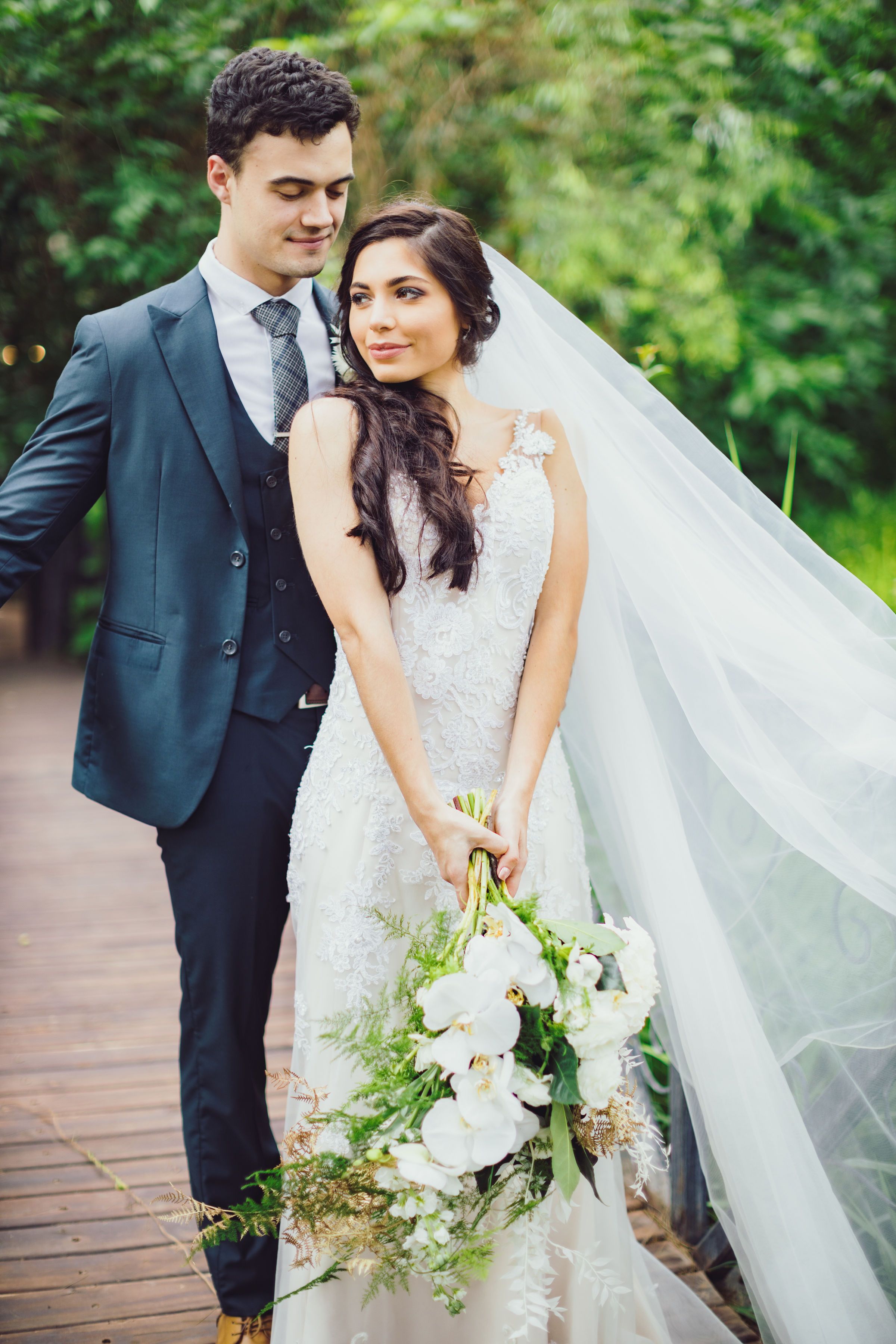 Bride and groom walking hand in hand through a rose garden after the ceremony