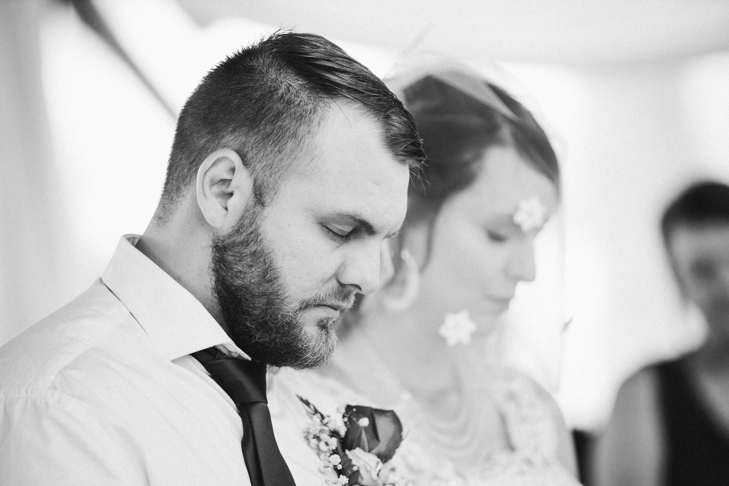 Bride and groom closing their eyes during prayer