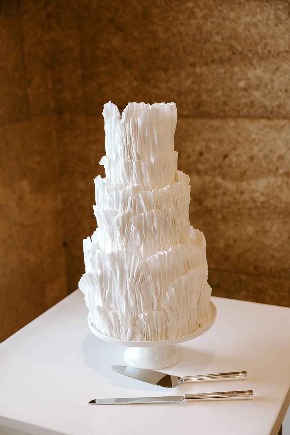 A time-lapse sequence showing the creation of a white layered paper sculpture on a table.