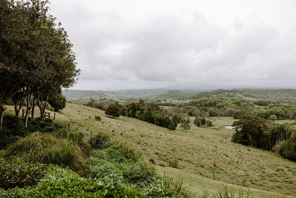 Rolling green hills and pastoral landscape under cloudy skies in a serene countryside setting.