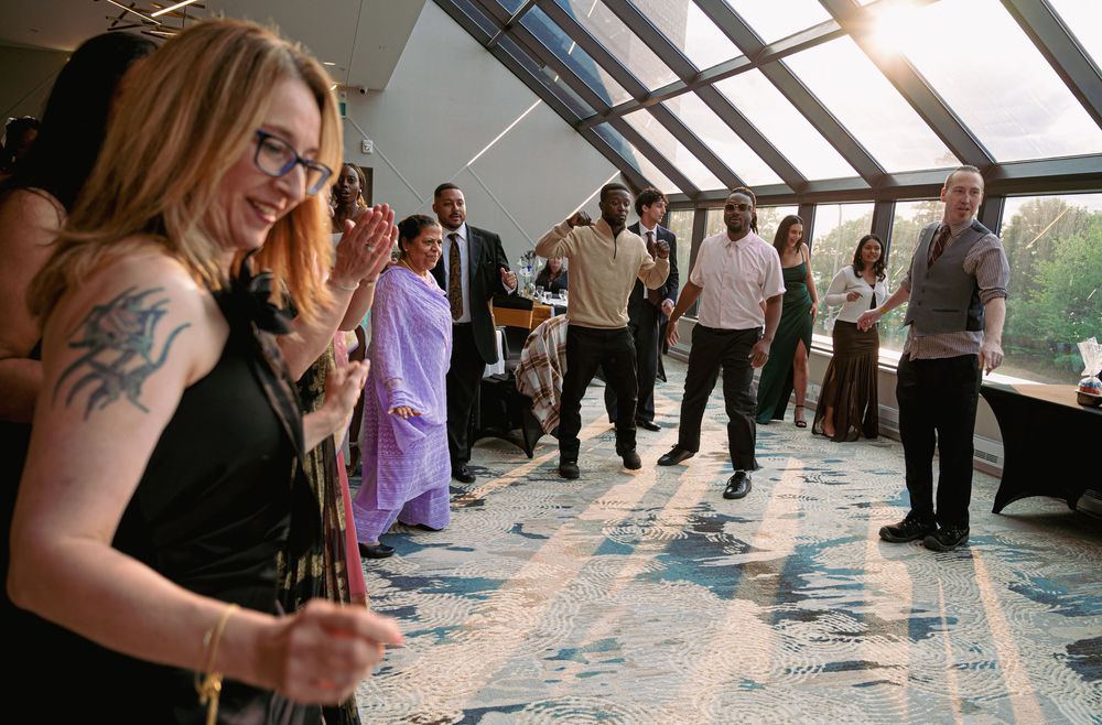 Guests enjoying a celebration in a modern venue with glass ceiling and city views.