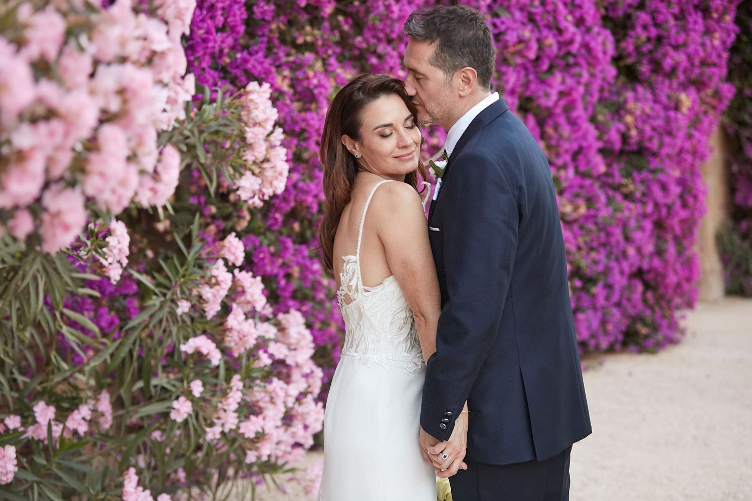 Fotografia di una coppia di sposi in una location semplice, ricca di fiori, che esprime dolcezza e eleganza. Colori curati.