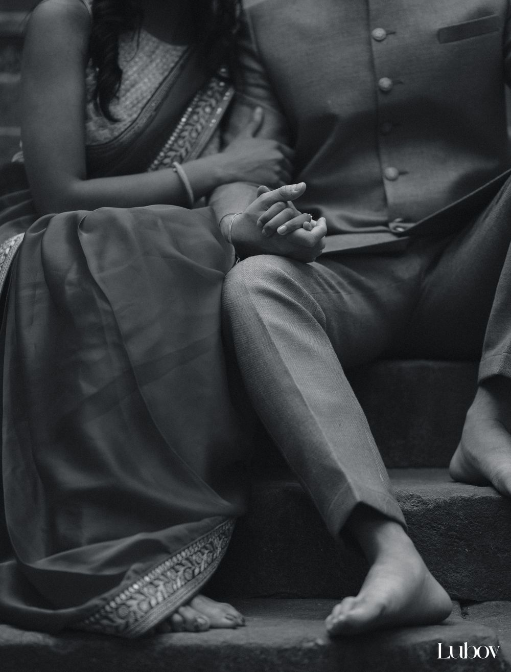 Intimate black and white detail shot of hands and traditional Indian clothing.